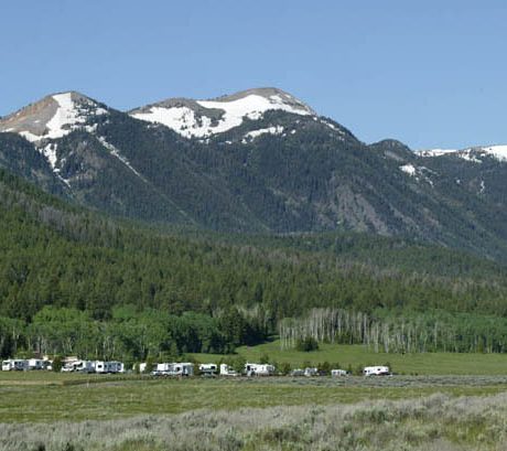 RV's parked near a mountain forest