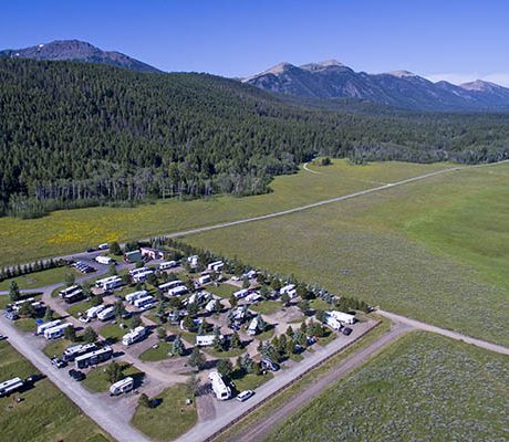 Aerial view of RV's parked near a mountainous forest